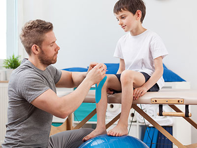 Physiotherapist working on a child's knee